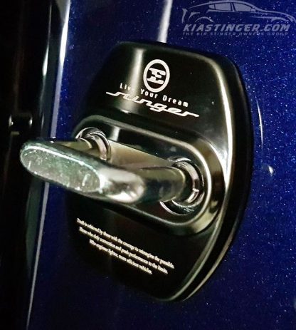 kia stinger door striker covers in black on a blue stinger