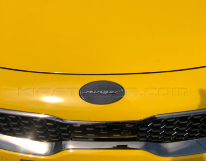 oval stinger emblem in black chrome gunmetal with black background on yellow kia stinger